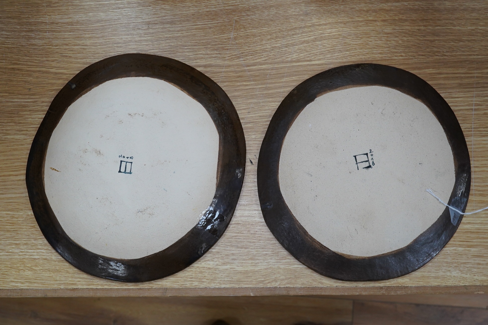 A pair of Eva Hernandez pottery plates, 26cm. Condition - good